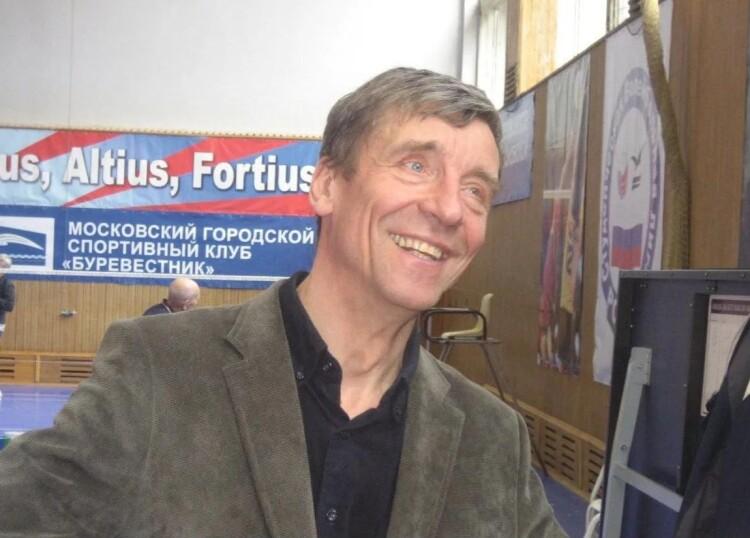 Улыбающийся мужчина в оливковом пиджаке в спортзале, за ним баннер МГСК «Буревестник» (фото: Александр Монастырев, badm.ru)